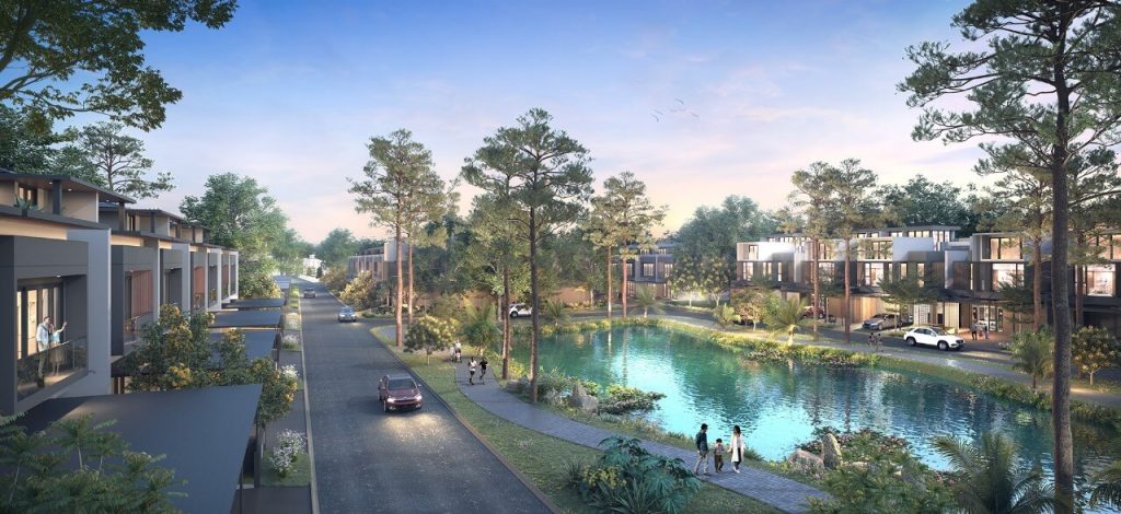 Modern residential neighborhood with a canal surrounded by townhouses, trees, and pedestrian paths; people walk along the water and cars travel on a tree-lined street at dusk/dawn light.